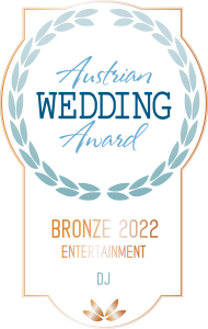 Ein Abzeichen mit einem Lorbeerkranz und der Aufschrift "Austrian Wedding Award". Darunter steht "Bronze 2022 Entertainment DJ" in blauer und bronzener Schrift auf weißem Hintergrund.
